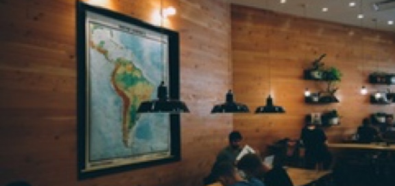 Students working at a table, large map in background