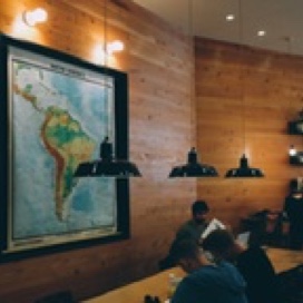 Students working at a table, large map in background